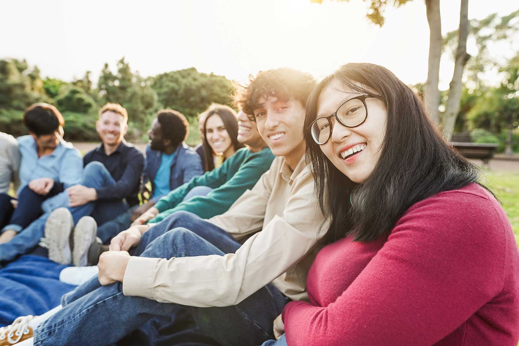 Friends gathered in a park, sitting and laughing together.